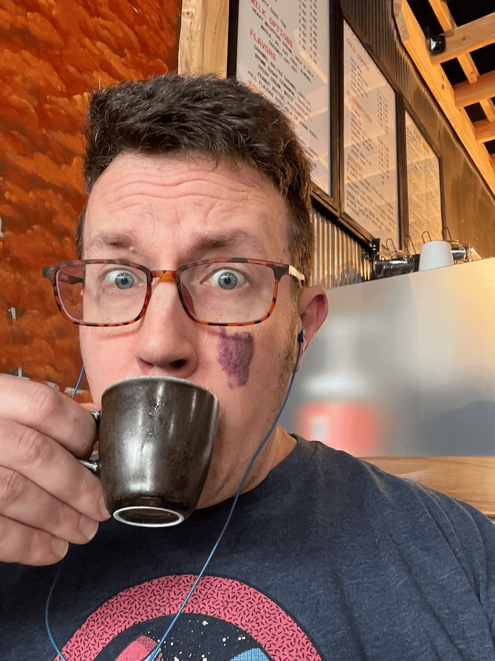 Pete McPherson sipping an espresso at a coffee bar.
